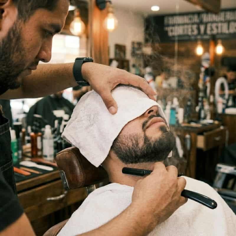 Aplicación de toalla caliente y navaja en el arreglo de barba en Mineral de la Reforma