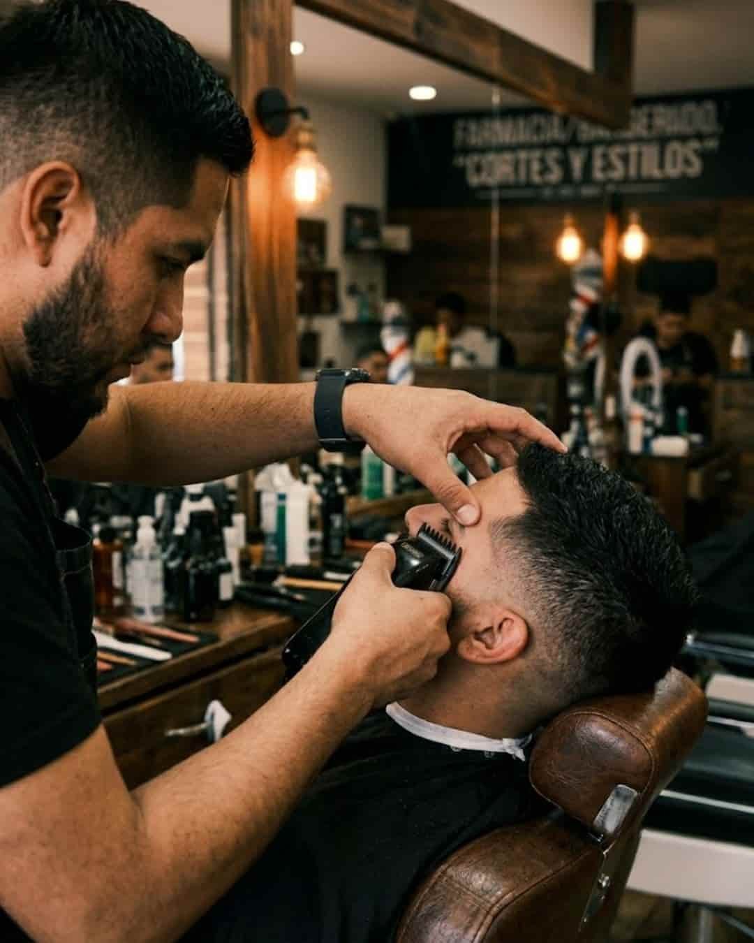 Barbero haciendo un fade a un cliente en una barbería en Mineral de la Reforma